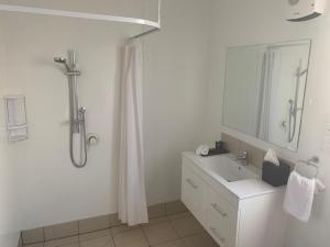 a bathroom with a shower and a sink and a mirror at Twizel Central Studio Accommodation in Twizel