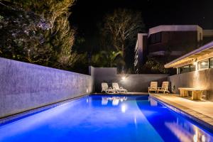 una piscina en un patio trasero por la noche en 84 The Spit Holiday Apartments en Mooloolaba