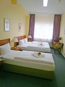 a hotel room with two beds and a window at Hotel Amadeus Central in Berlin