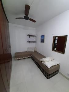 a bed in a room with a ceiling fan at Vista Panorâmica em São Pedro da Aldeia in Rio de Janeiro