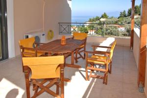 a wooden table and chairs on a balcony at Achladi Beach in Achladi
