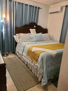 um quarto com uma cama grande e cortinas azuis em Natural Village #1,2,3 & 5 em San Juan