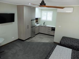 a kitchen with a couch and a ceiling fan at Barooga River Gums Motor Inn in Barooga