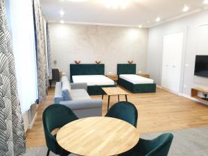 - un salon avec deux lits et deux tables dans l'établissement Apartamenty Centrum - Mickiewicza, à Bielsko-Biała