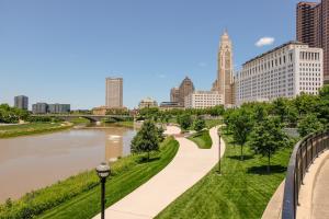 a city street with tall buildings and a river at FRONTDESK LC Riversouth 205 Apts Downtown Columbus in Columbus