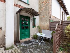 a green door and a table in front of a building at Vacation apartment in Usedom on the Baltic Sea in Stolpe auf Usedom
