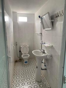 un baño con inodoro y lavabo en Nhà Nghỉ Hải Linh, en Ha Giang