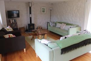 ein Wohnzimmer mit zwei Sofas und einem Kamin in der Unterkunft The Barn @ Mill Haven Place, 3 bedroom cottage in Haverfordwest