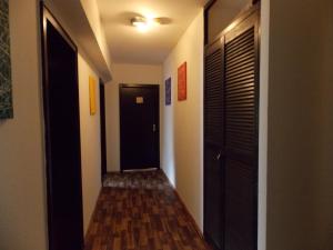 a hallway with a black door and a wooden floor at Hotel Talburg in Heiligenhaus