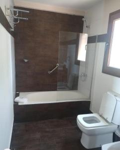 y baño con bañera, aseo y ducha. en excelente departamento 4 personas villa Dina huapi 2 ambientes amplios PB en Dina Huapi