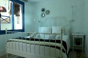 a bedroom with a white bed and a window at Trisara - Las Playitas in Las Playas