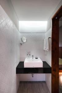 bagno con lavandino bianco e bancone nero di Nenggao Club B&B a Puli