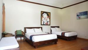 
a hotel room with a bed, desk, and chair at Puri Rinjani Bungalows in Kuta Lombok
