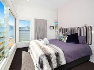 a bedroom with a bed and a large window at The Wharf House at Budgewoi in Budgewoi