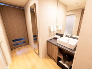 a bathroom with a sink and a mirror at Kawagoe Tobu Hotel in Kawagoe