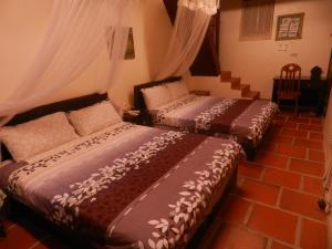 金沙鎮的住宿－山后海珠民宿，两张床铺,位于带窗帘的房间