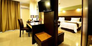 una camera d'albergo con un letto, una scrivania e una camera da letto di The Naripan Hotel a Bandung