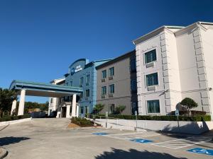 a large white building with a parking lot at Best Western Houston Bush IAH Intercontinental Airport Inn in Humble