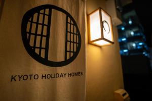 Guesthouse Chayama في كيوتو: ضوء على جدار مع علامة koko عطلة المنازل