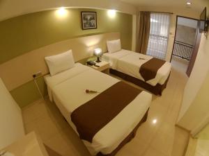 una camera d'albergo con due letti e una finestra di The Naripan Hotel a Bandung
