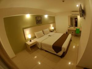 una camera d'albergo con un grande letto e un bagno di The Naripan Hotel a Bandung