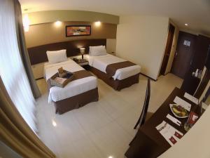 una camera d'albergo con due letti e un tavolo di The Naripan Hotel a Bandung