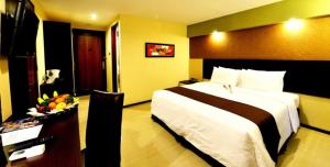 una camera d'albergo con un letto grande e un tavolo di The Naripan Hotel a Bandung