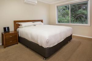 a bedroom with a large bed and a window at Eagle Bay Beach House in Dunsborough