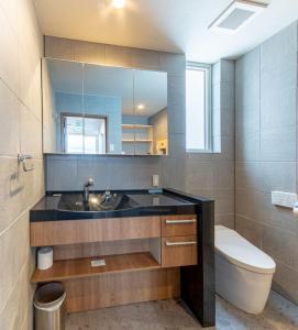 uma casa de banho com um lavatório, um WC e um espelho. em Kitsune House - walking distance to Rusutsu Resort em Rusutsu