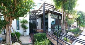 a home with a black railing and trees at Areena Hotel Phitsanulok in Phitsanulok