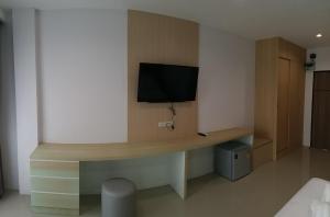 een kamer met een bureau en een tv aan de muur bij Areena Hotel Phitsanulok in Phitsanulok