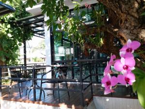 een groep tafels en stoelen onder een boom bij Areena Hotel Phitsanulok in Phitsanulok