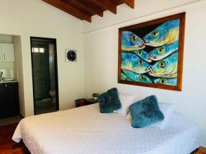 a bedroom with a bed with a painting on the wall at Hotel Lleras Premium #1 in Medellín