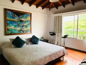 a bedroom with a bed with a painting on the wall at Hotel Lleras Premium #1 in Medellín +220 photos