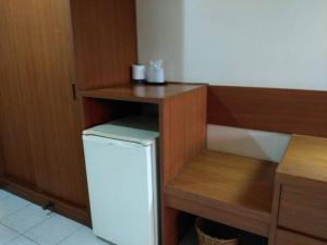 Ban Dan Changにあるโรงแรมฉัตรแก้วの小型冷蔵庫と木製の棚を備えたキッチン