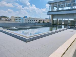a building with a swimming pool in front of a building at Grand Sydney Hotel in Batam Center