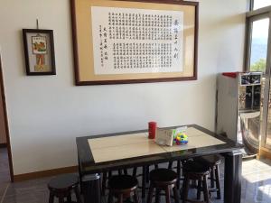 una mesa con taburetes en una habitación con un calendario en la pared en 悟 佐茶 Satori tea en Leye