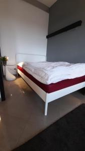 デュッセルドルフにあるFerienwohnungen Bormacherの赤と白のマットレスが備わる客室の白いベッド1台分です。