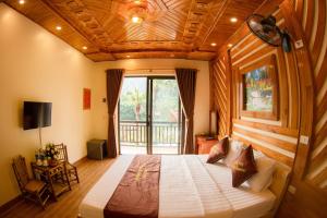 a bedroom with a large bed with a wooden ceiling at HoangLong Riverside Homestay in Ninh Binh