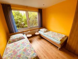1 Schlafzimmer mit 2 Betten und einem Fenster in der Unterkunft Ferienhaus Maxe, Wohnung Joona in Wulfen auf Fehmarn