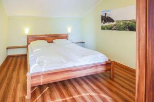 a large bed in a room with wooden floors at Buedlfarm-Sued in Sahrensdorf