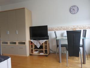 ein Wohnzimmer mit einem Tisch und einem Flachbild-TV in der Unterkunft SONNENSCHEIN  in Burgtiefe auf Fehmarn 