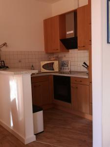 eine Küche mit Holzschränken und einer Mikrowelle in der Unterkunft Bi de Kark in Sankt Peter-Ording