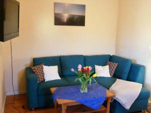 a blue couch with a vase of flowers on a table at Ostsee-Ferienoase-2-Raum-App-Typ-3 in Klütz