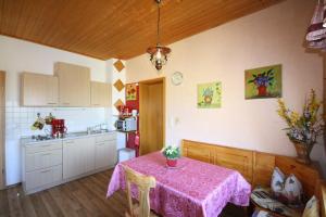 Neudorf的住宿－Grosse-Ferienwohnung-Ebert-Green，厨房配有带粉色桌布的桌子