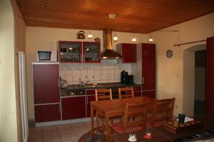 a kitchen with red cabinets and a wooden table at FEWO-im-sanierten-Fachwerkhaus in Müglitztal