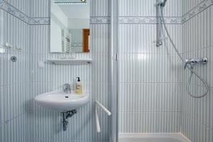 Un baño blanco con lavabo y ducha. en Sylt-Bungalow, en Westerland