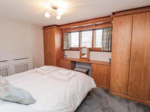 a bedroom with a bed and a wooden cabinet at 3 Tidal in Rye