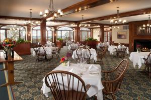 a dining room with tables and chairs with white table settings at Black Point Inn in Scarborough