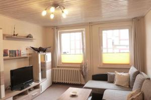ヴェルニゲローデにあるWernigerode-Ferienwohnung-Schultzのリビングルーム(ソファ、テレビ、窓2つ付)